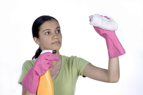 Professional cleaner refreshing a short-let kitchen during an Enfield turnover
